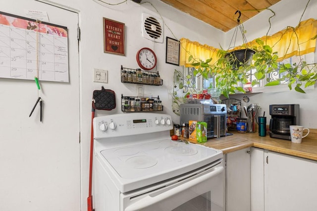 kitchen featuring white cabinets and white electric range