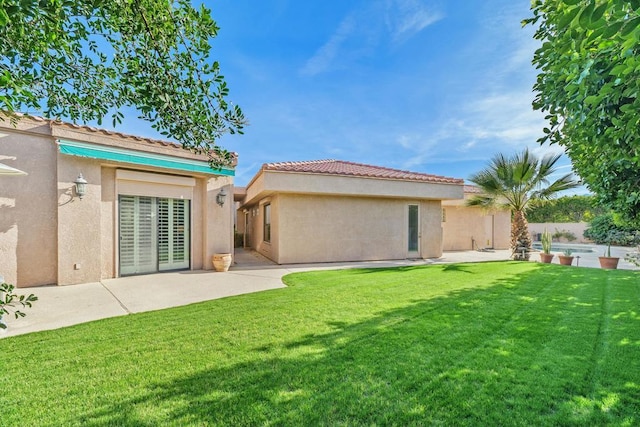 back of property with a patio and a lawn