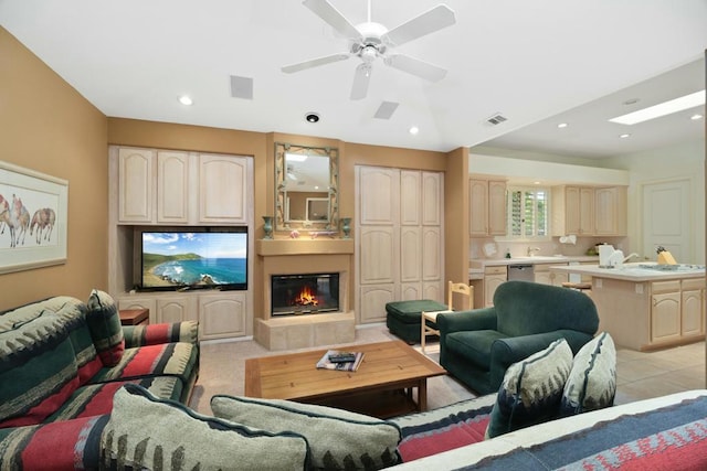 living room with a tile fireplace and ceiling fan