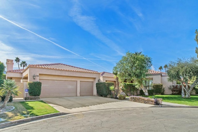 mediterranean / spanish-style house with a garage and a front yard