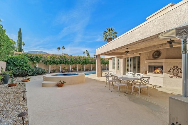 view of patio with a fenced in pool, ceiling fan, and exterior fireplace