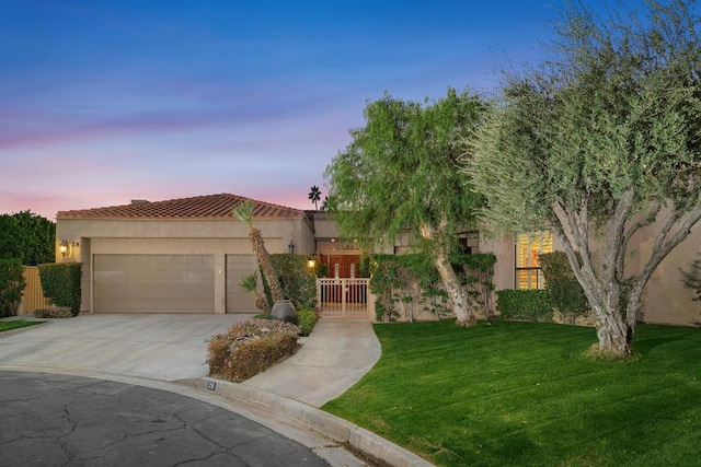 view of front of property with a yard and a garage