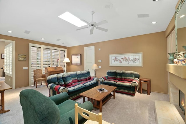 living room featuring ceiling fan, light colored carpet, and a fireplace