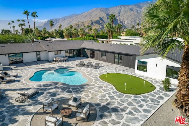 view of pool with a patio area, a mountain view, and an outdoor fire pit