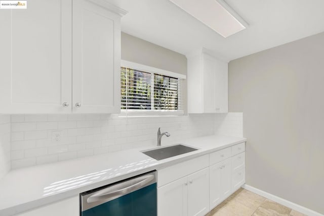 kitchen featuring white cabinetry, stainless steel dishwasher, tasteful backsplash, and sink