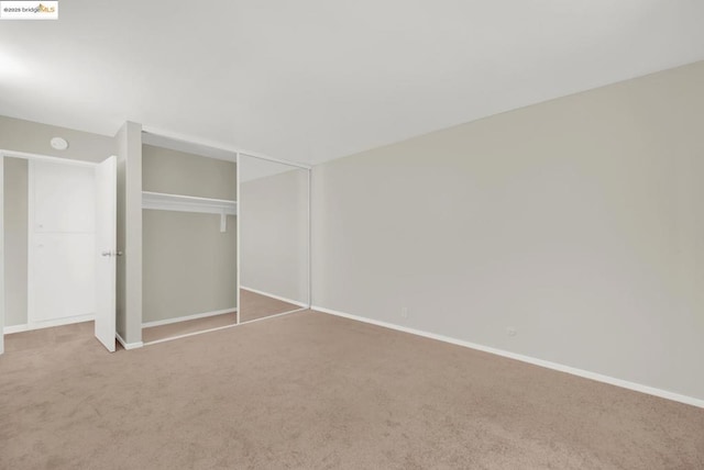 unfurnished bedroom with carpet flooring and a closet