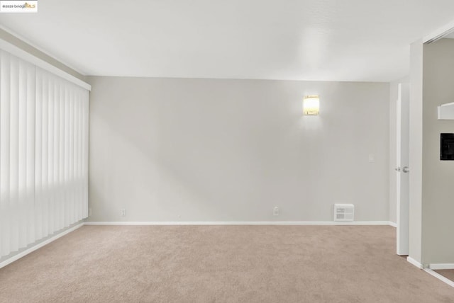 unfurnished room featuring light carpet