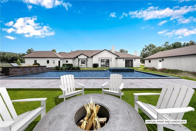 view of swimming pool featuring a patio, a yard, and a fire pit