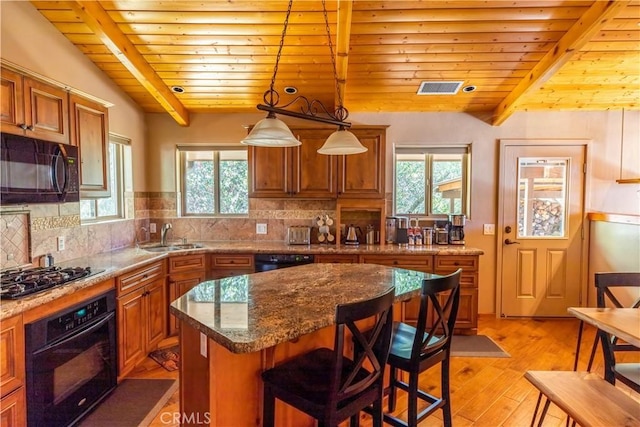 kitchen with wooden ceiling, light hardwood / wood-style flooring, pendant lighting, a kitchen island, and black appliances