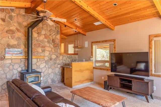 living room with a wood stove, light carpet, lofted ceiling with beams, ceiling fan, and wood ceiling