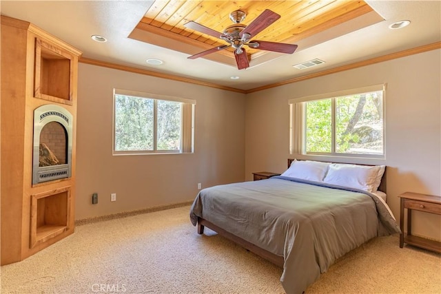 carpeted bedroom featuring a tray ceiling, ceiling fan, wood ceiling, and ornamental molding