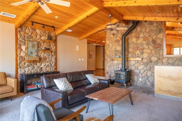 living room with wood ceiling, a wood stove, carpet, and lofted ceiling with beams