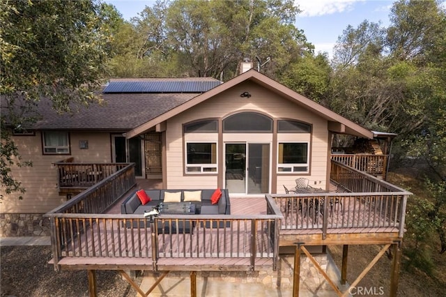 rear view of property with outdoor lounge area, solar panels, and a deck