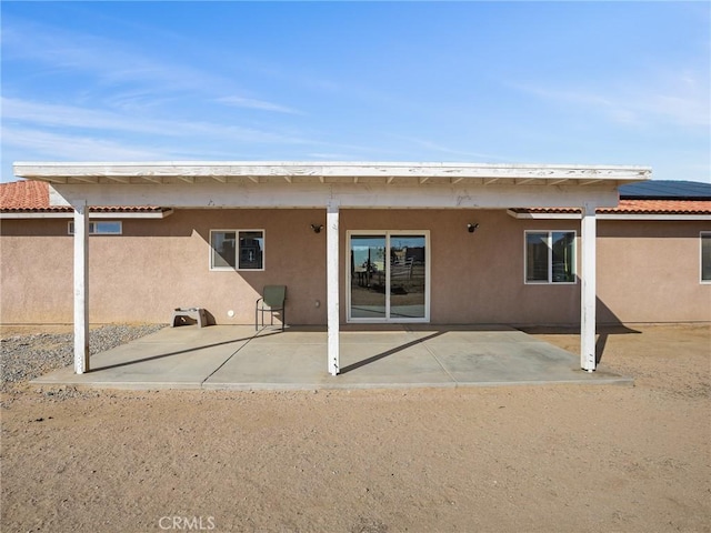 7755 7th St, Phelan, CA 92371 - rear view of property featuring a patio area, stucco siding, a tiled roof, and solar panels