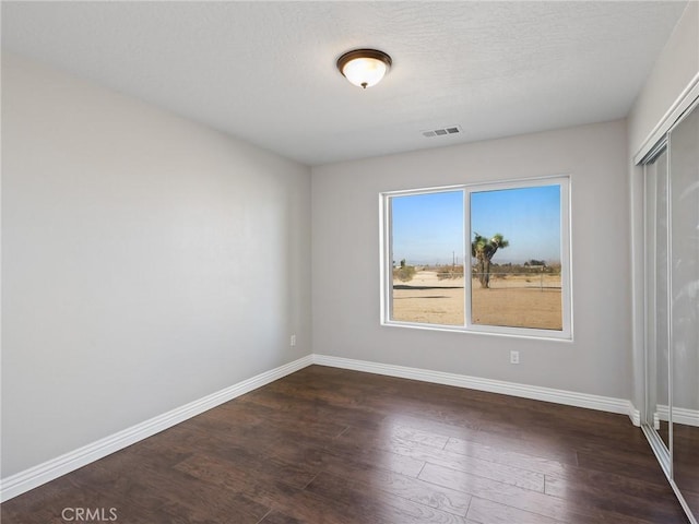 7755 7th St, Phelan, CA 92371 - empty room with dark wood-type flooring and baseboards
