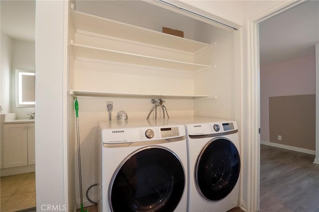 laundry area with light hardwood / wood-style flooring and washing machine and clothes dryer