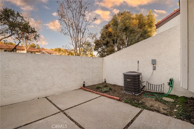 patio terrace at dusk with central air condition unit