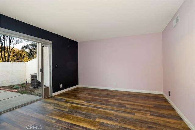 unfurnished room with dark wood-type flooring