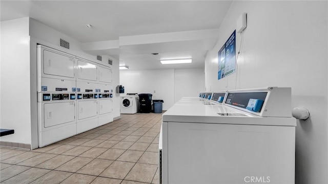 interior space featuring washer and clothes dryer, stacked washing maching and dryer, and light tile patterned flooring