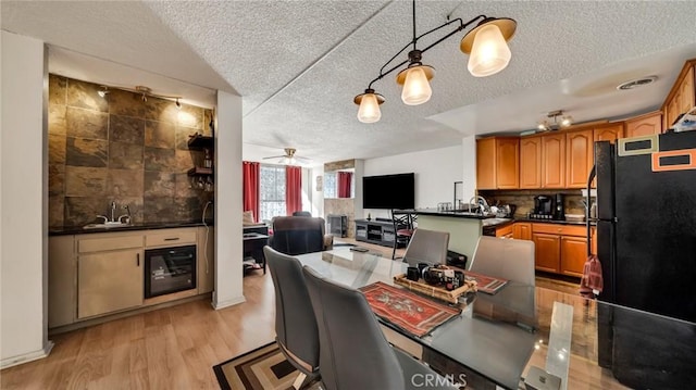 6435 Green Valley Cir Unit 214, Culver City, CA 90230 - kitchen with freestanding refrigerator, a textured ceiling, dark countertops, tasteful backsplash, and beverage cooler