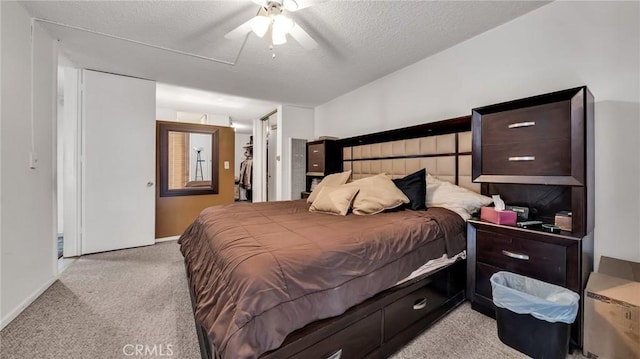 carpeted bedroom with ceiling fan, a closet, and a textured ceiling