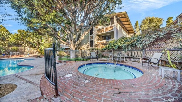 view of pool featuring a hot tub and a patio