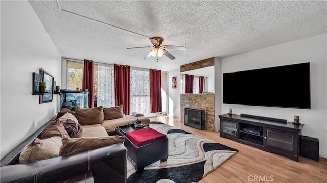 6435 Green Valley Cir Unit 214, Culver City, CA 90230 - living area with ceiling fan, wood finished floors, a textured ceiling, and a fireplace