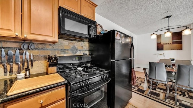 kitchen with black appliances, dark countertops, and backsplash