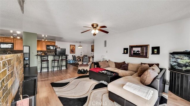 living room with light hardwood / wood-style floors and a textured ceiling