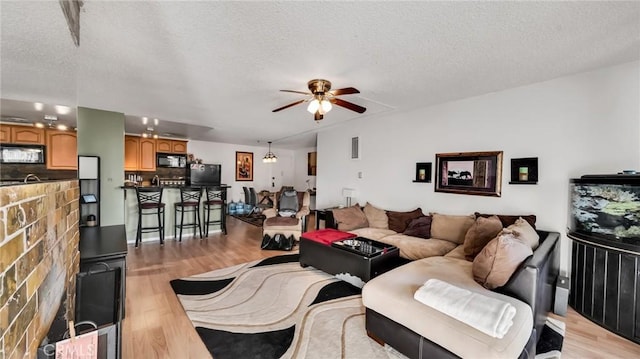 6435 Green Valley Cir Unit 214, Culver City, CA 90230 - living area with light wood-style flooring, a ceiling fan, and a textured ceiling