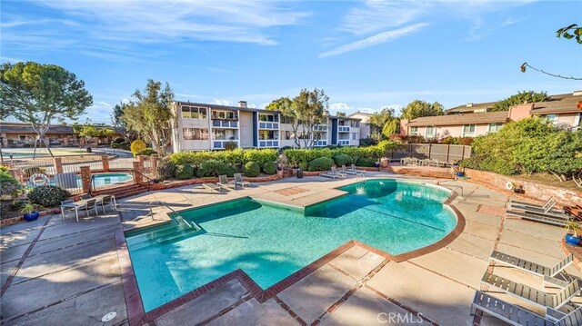 view of swimming pool featuring a community hot tub and a patio