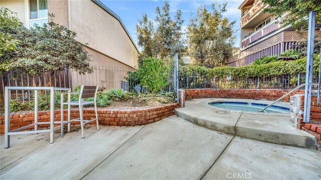 view of swimming pool with a hot tub and a patio