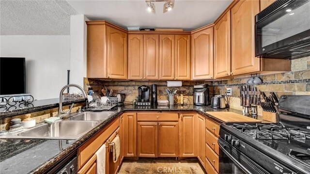 kitchen with black appliances, backsplash, dark stone counters, and sink