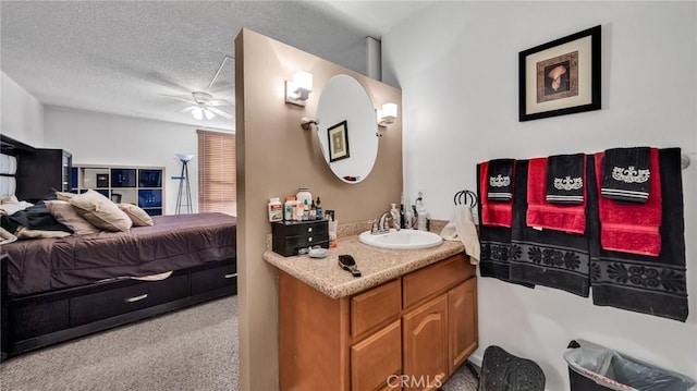 bathroom with ceiling fan, vanity, and a textured ceiling