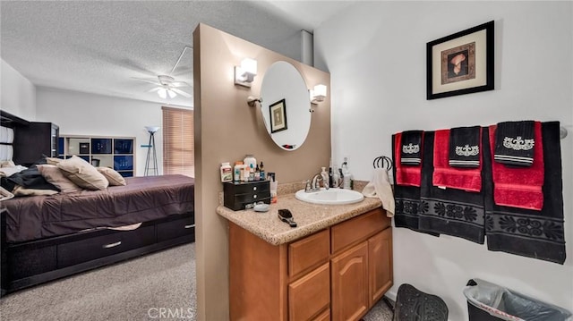 bathroom with ceiling fan, a textured ceiling, vanity, and ensuite bathroom