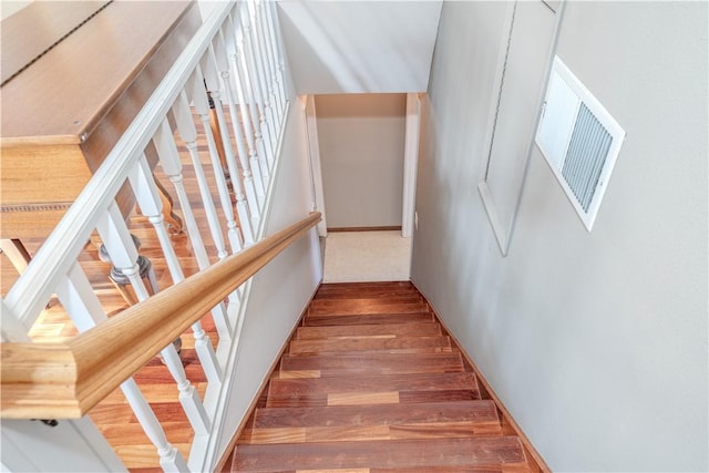 staircase featuring visible vents and wood finished floors