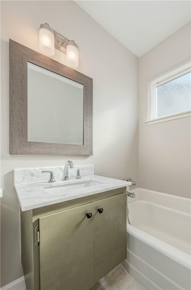 bathroom featuring a garden tub and vanity