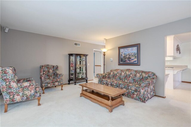 living area with light carpet and visible vents