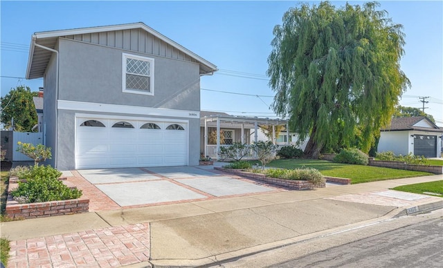 traditional home with stucco siding, concrete driveway, and a front yard