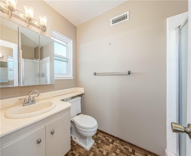 full bathroom featuring toilet, vanity, a shower stall, and visible vents