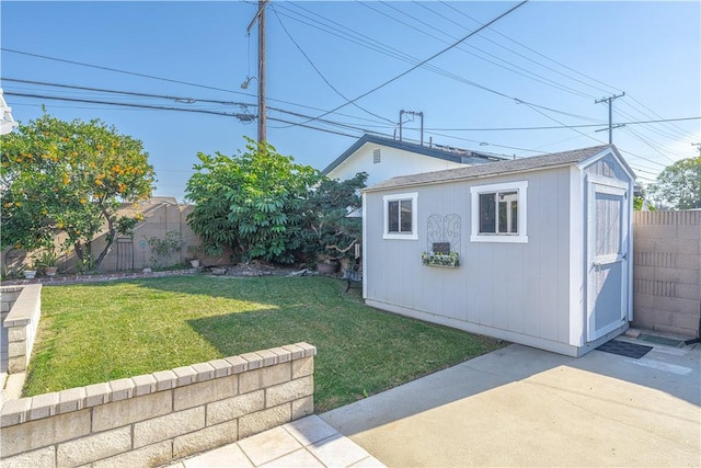 view of yard featuring a fenced backyard, a shed, and an outdoor structure