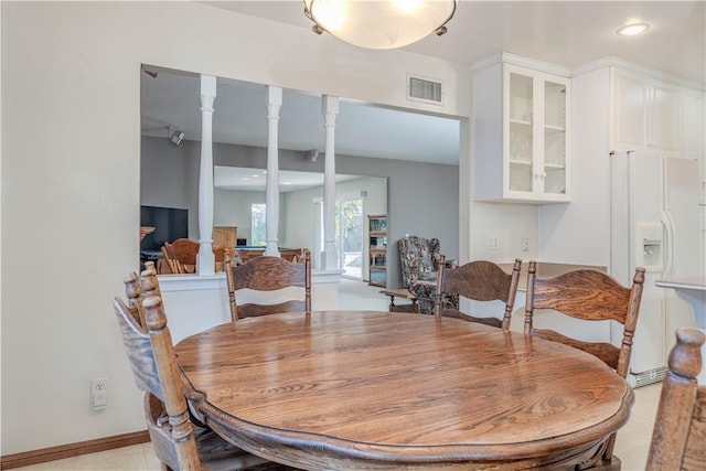 dining area featuring decorative columns and visible vents