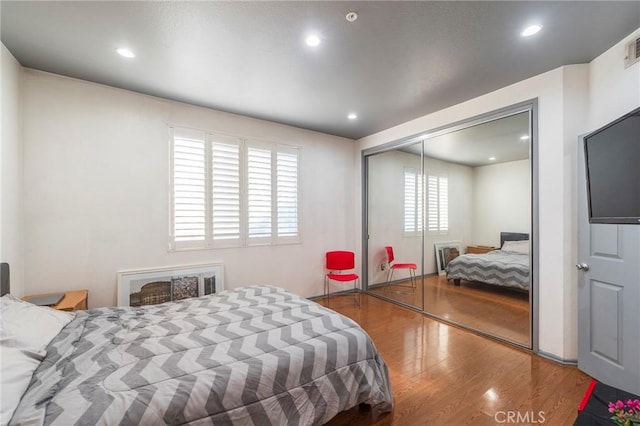 bedroom with wood-type flooring and a closet