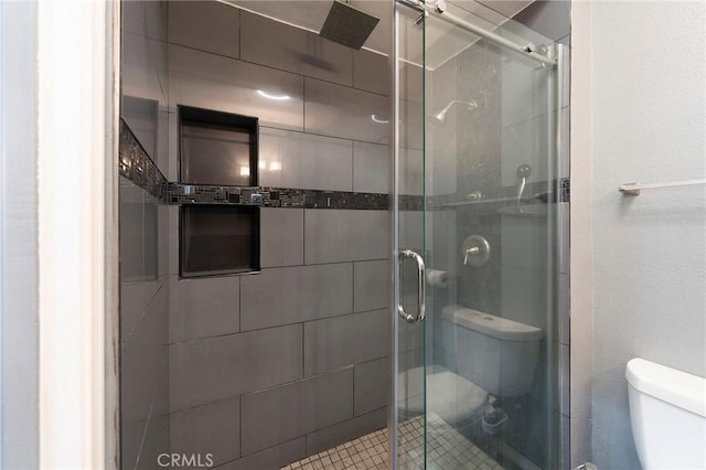 bathroom featuring an enclosed shower and toilet