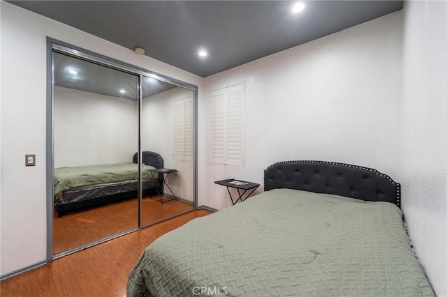 bedroom with hardwood / wood-style floors and a closet