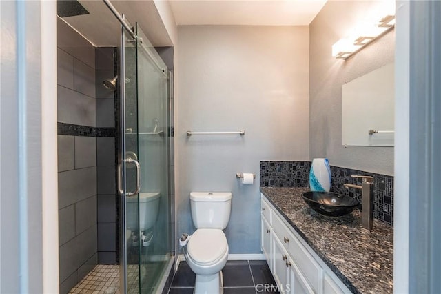 bathroom featuring tile patterned flooring, vanity, an enclosed shower, and toilet