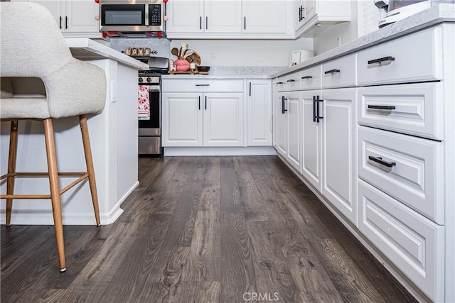 kitchen featuring appliances with stainless steel finishes, white cabinetry, and dark wood-type flooring