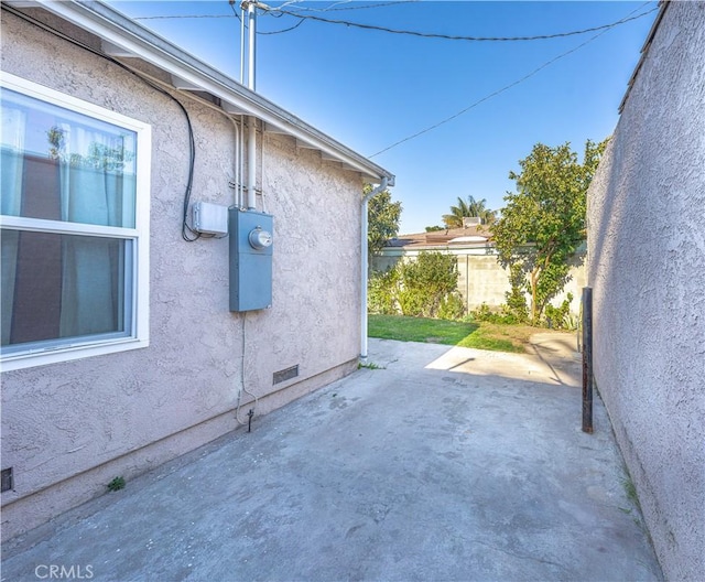 view of property exterior with crawl space, a patio area, fence, and stucco siding