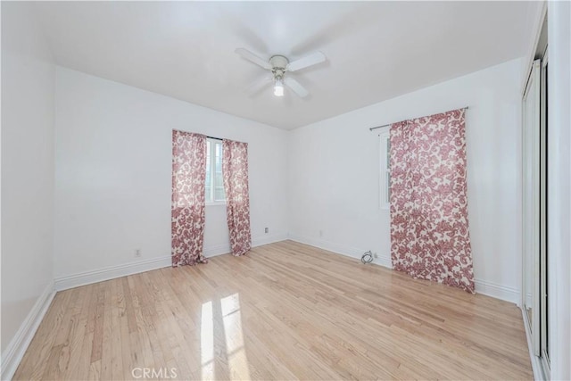 empty room with baseboards, light wood-style flooring, and a ceiling fan