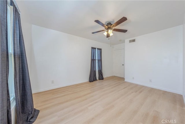 spare room with a ceiling fan, baseboards, visible vents, and light wood finished floors